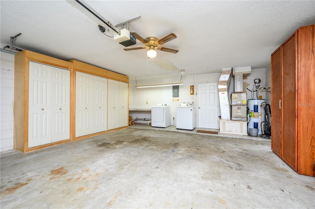 garage with a garage door opener, electric water heater, heating unit, and independent washer and dryer