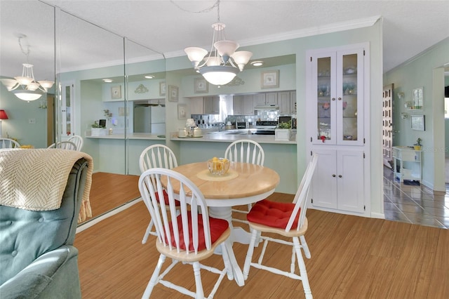 600 N Boundary Ave Unit 114B, Deland, FL 32720 - dining space with ornamental molding, a chandelier, light wood-style flooring, and a textured ceiling