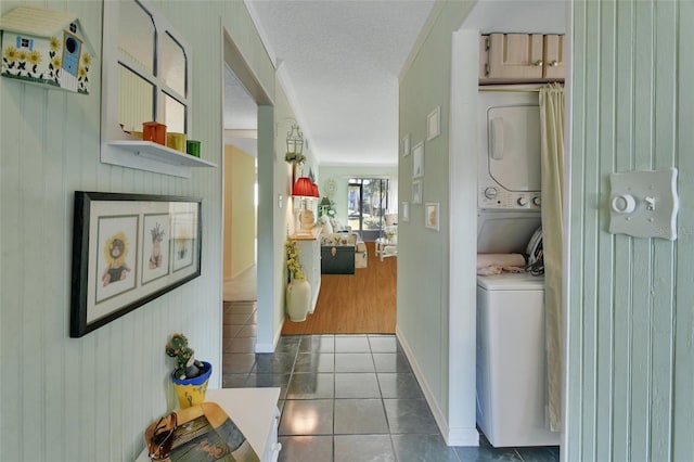 600 N Boundary Ave Unit 114B, Deland, FL 32720 - laundry room with stacked washer / dryer, tile patterned floors, a textured ceiling, and wooden walls