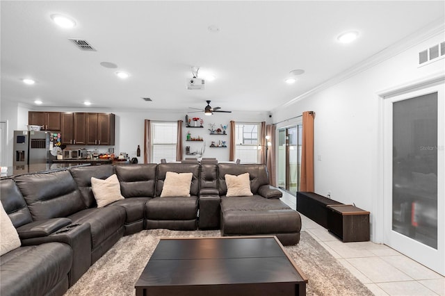 living room with ceiling fan, ornamental molding, and light tile patterned floors