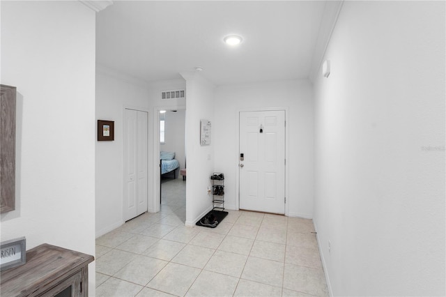 tiled foyer entrance with crown molding