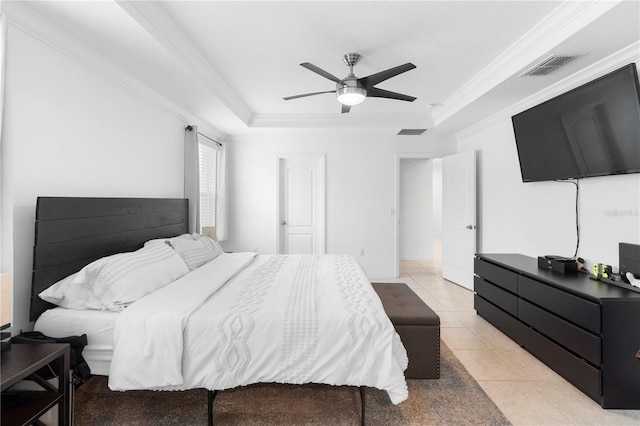 tiled bedroom with ceiling fan, ornamental molding, and a tray ceiling