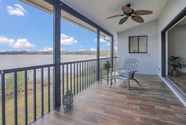 sunroom / solarium with lofted ceiling, ceiling fan, and a water view