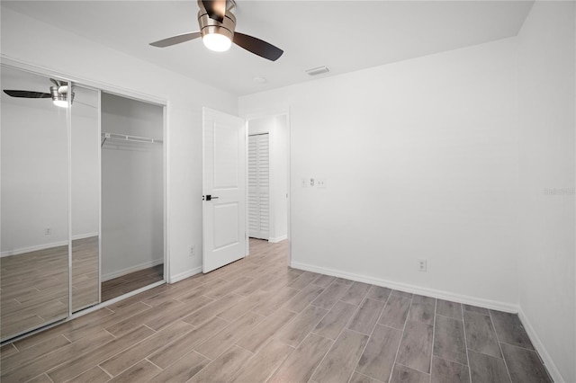 unfurnished bedroom featuring ceiling fan and a closet