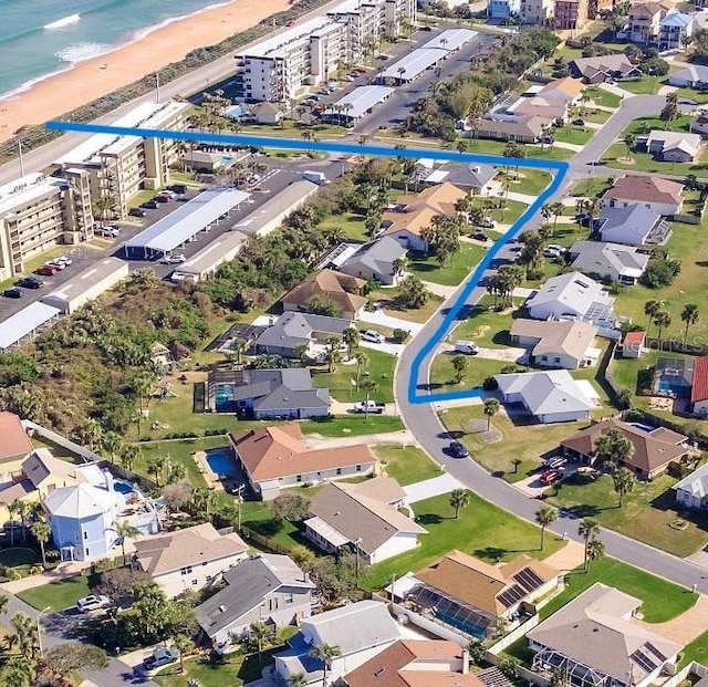 drone / aerial view with a water view and a beach view