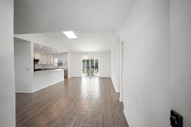 unfurnished living room featuring a skylight and wood-type flooring