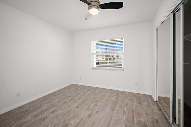 unfurnished bedroom featuring ceiling fan, a closet, and light wood-type flooring