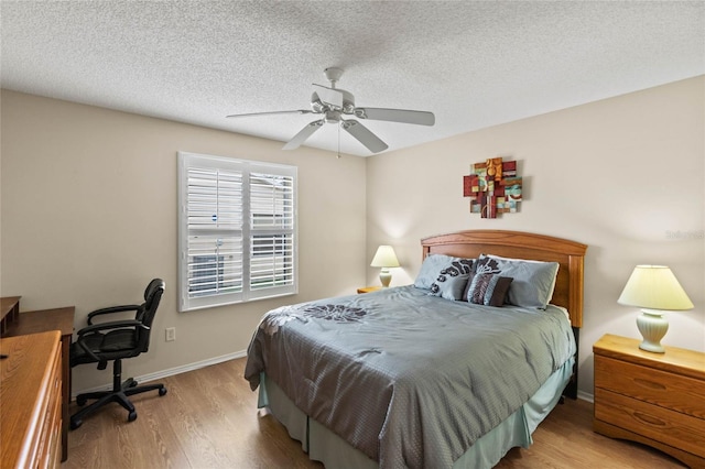 bedroom with ceiling fan, a textured ceiling, and light wood-type flooring