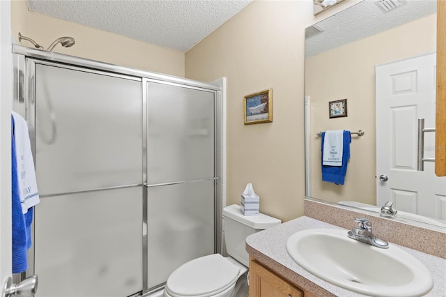 bathroom featuring vanity, an enclosed shower, a textured ceiling, and toilet