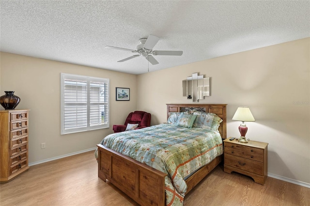 bedroom with a textured ceiling, light hardwood / wood-style floors, and ceiling fan