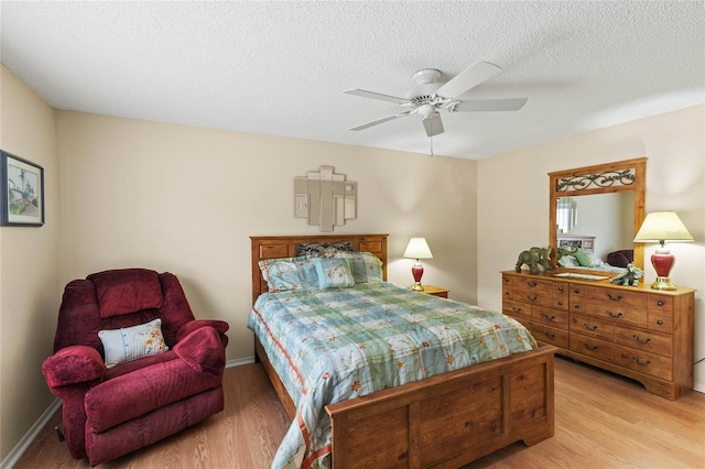 bedroom featuring ceiling fan, a textured ceiling, and light hardwood / wood-style floors