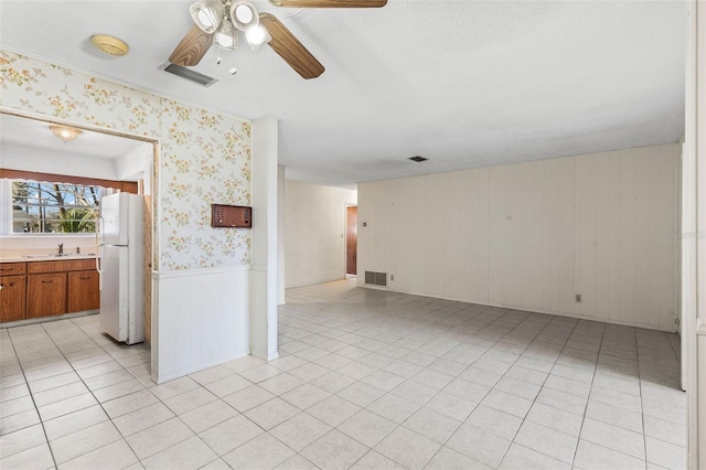 tiled empty room with ceiling fan and sink