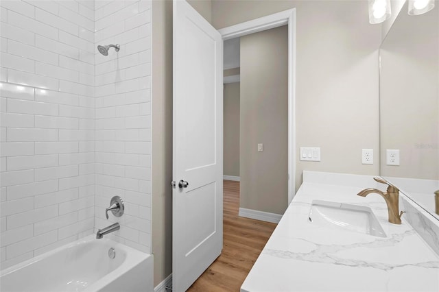 bathroom with tiled shower / bath combo, vanity, and hardwood / wood-style floors