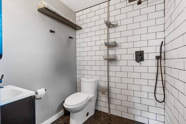bathroom featuring vanity, toilet, and a tile shower