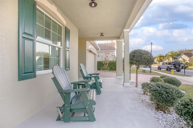 view of patio / terrace with a garage and covered porch