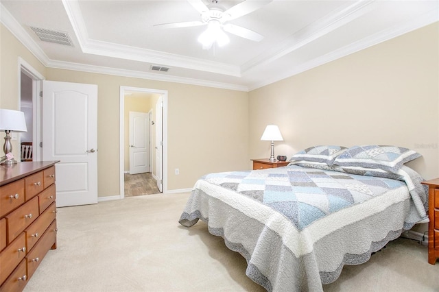 bedroom with crown molding, ceiling fan, a tray ceiling, and light carpet