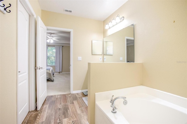 bathroom with wood-type flooring and tiled bath