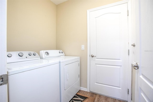 clothes washing area featuring washer and clothes dryer and hardwood / wood-style floors