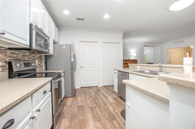 kitchen featuring stainless steel appliances, white cabinetry, sink, and ornamental molding