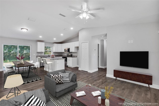 living room featuring vaulted ceiling, dark wood-type flooring, and ceiling fan