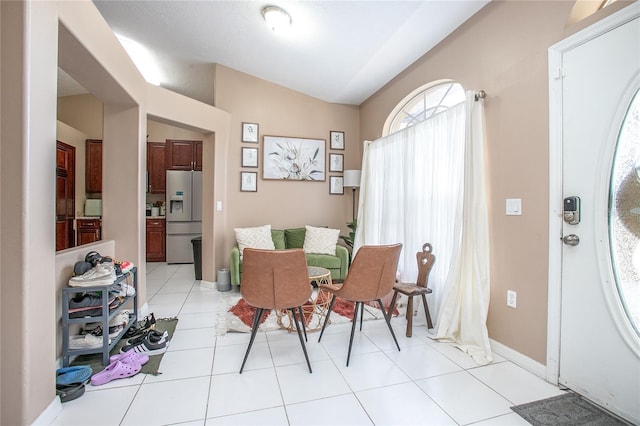 dining room with lofted ceiling and light tile patterned floors