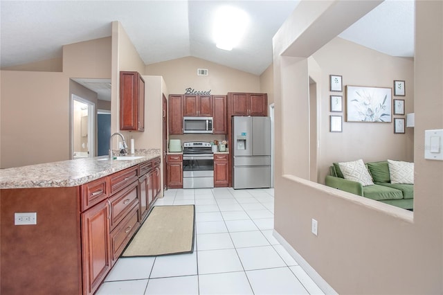 kitchen featuring lofted ceiling, sink, light tile patterned floors, and appliances with stainless steel finishes