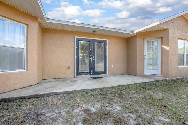 view of exterior entry featuring french doors and a patio area