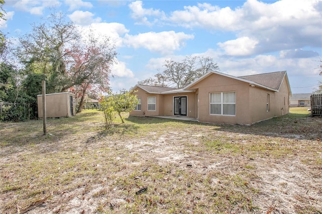 rear view of house featuring a storage shed