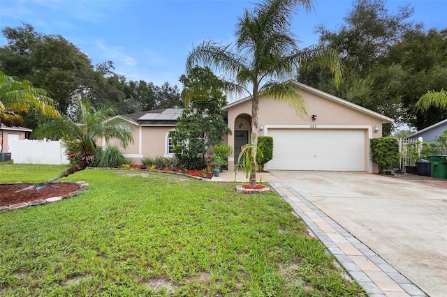 ranch-style home with a garage, a front lawn, and solar panels