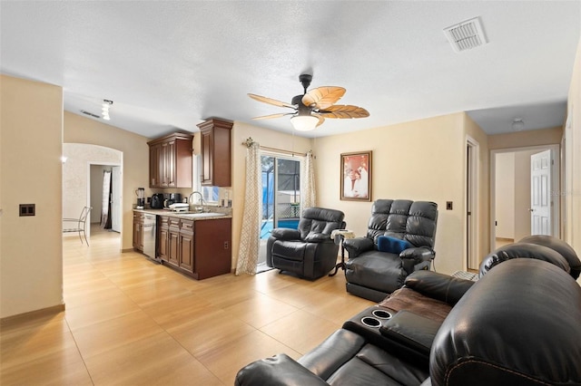 tiled living room featuring sink, a textured ceiling, vaulted ceiling, and ceiling fan