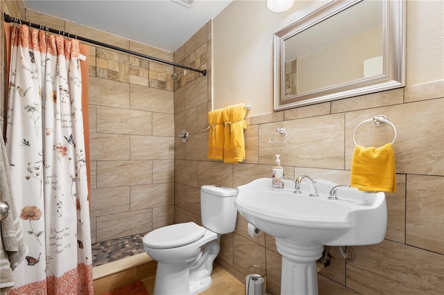 bathroom with a shower with curtain, toilet, and tile walls