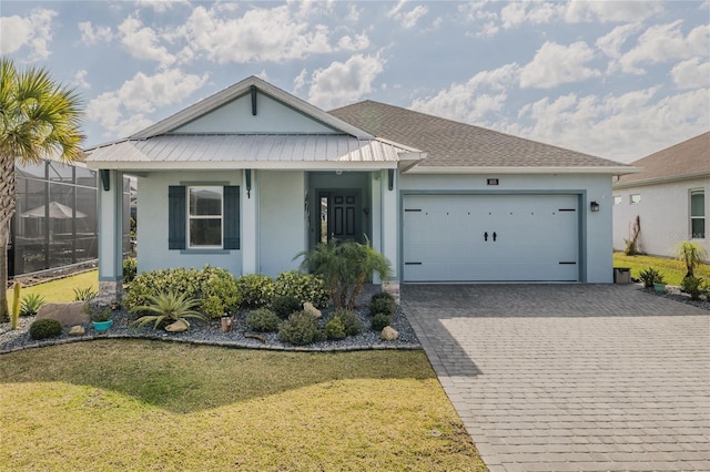 view of front of house with a garage, glass enclosure, and a front lawn