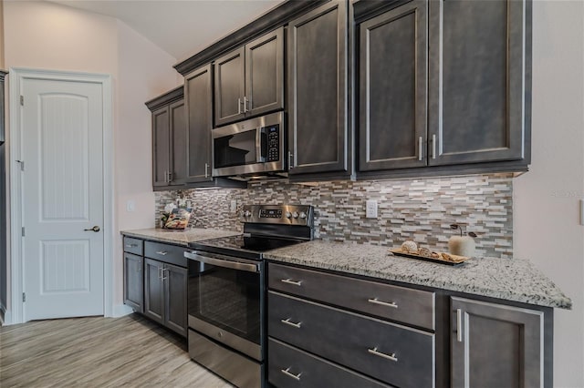 kitchen with decorative backsplash, stainless steel appliances, dark brown cabinetry, and light hardwood / wood-style flooring