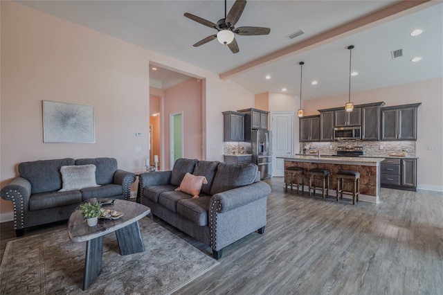 living room with ceiling fan, dark hardwood / wood-style flooring, and beam ceiling