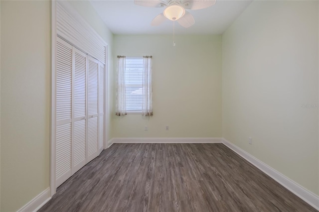 unfurnished bedroom featuring a closet, dark wood-type flooring, and ceiling fan