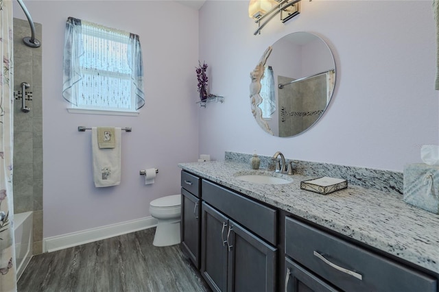 full bathroom with tiled shower / bath combo, toilet, hardwood / wood-style flooring, and vanity