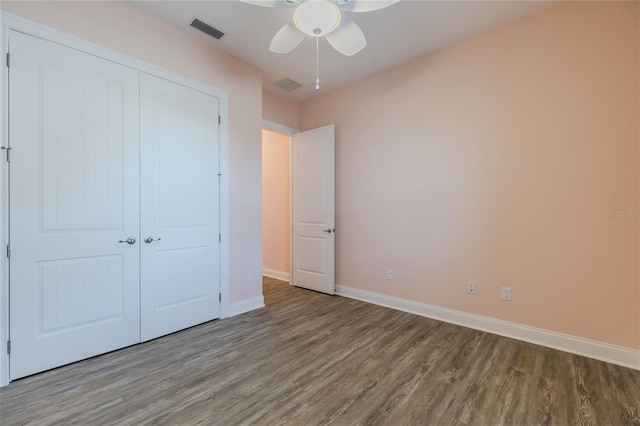 unfurnished bedroom featuring ceiling fan, a closet, and wood-type flooring