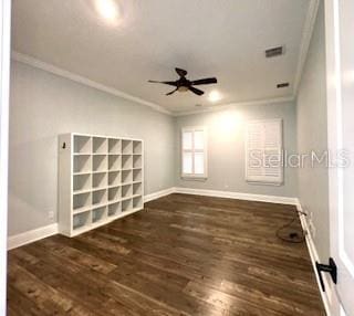 spare room featuring crown molding, dark wood-type flooring, and ceiling fan