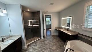 bathroom with vanity, separate shower and tub, and plenty of natural light