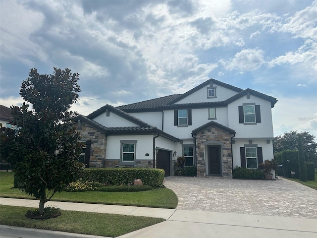 6301 Swanson St, Windermere, FL 34786 - view of front of house with stone siding, decorative driveway, stucco siding, and an attached garage