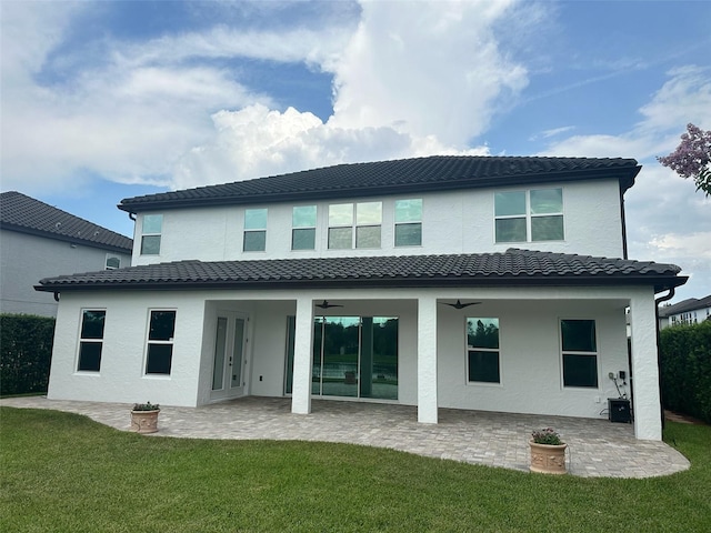 6301 Swanson St, Windermere, FL 34786 - back of house featuring a lawn, a ceiling fan, a tile roof, and stucco siding