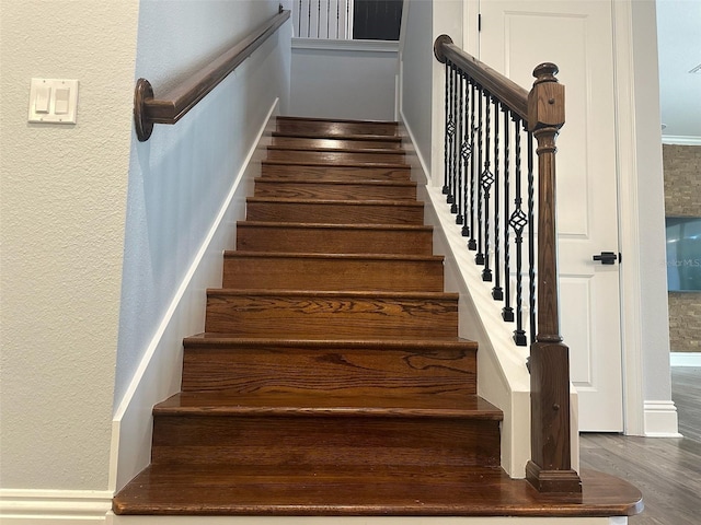 6301 Swanson St, Windermere, FL 34786 - staircase featuring wood finished floors and a textured wall