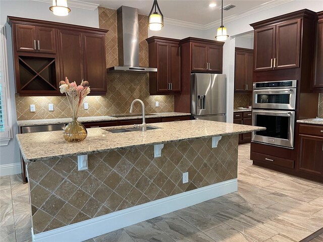 6301 Swanson St, Windermere, FL 34786 - kitchen featuring wall chimney exhaust hood, appliances with stainless steel finishes, ornamental molding, an island with sink, and pendant lighting