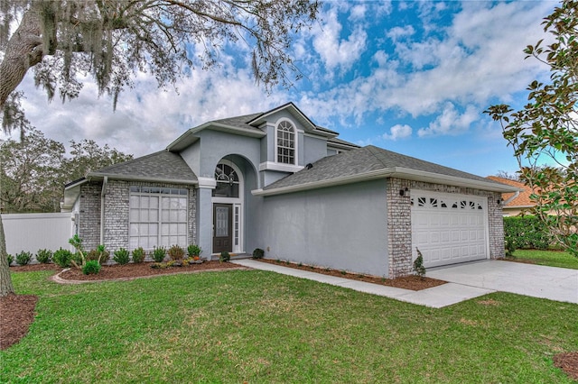 traditional home featuring an attached garage, concrete driveway, roof with shingles, stucco siding, and a front lawn