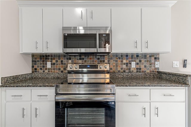 kitchen with tasteful backsplash, appliances with stainless steel finishes, white cabinets, and dark stone countertops