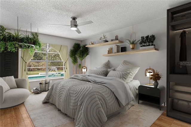 bedroom featuring a textured ceiling, ceiling fan, and wood finished floors