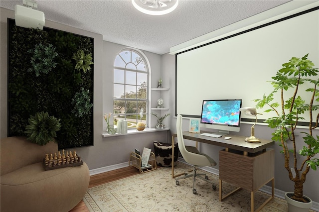 office with baseboards, light wood-style flooring, and a textured ceiling