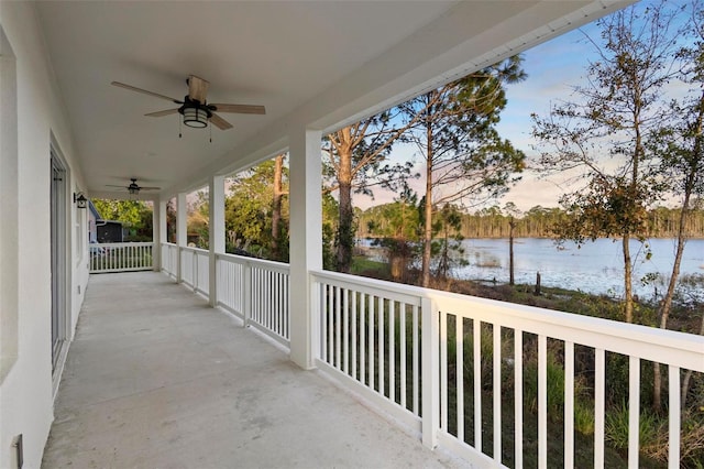 view of patio with a water view and ceiling fan