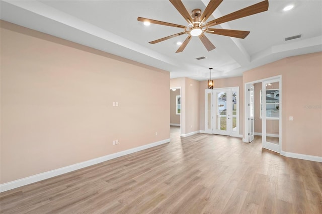 spare room with visible vents, ceiling fan, light wood-style flooring, and baseboards