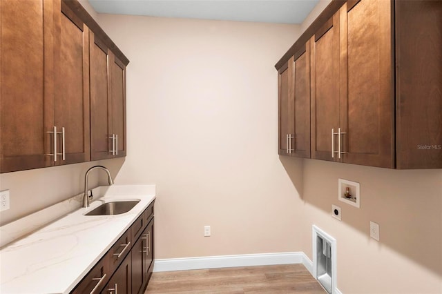 clothes washing area featuring cabinet space, baseboards, a sink, hookup for a washing machine, and electric dryer hookup